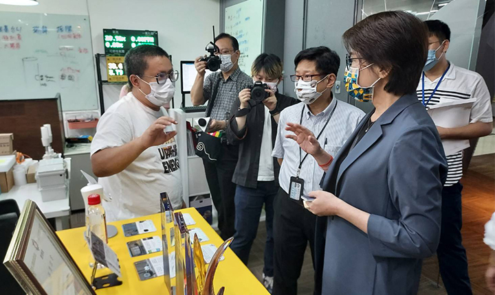 璽樂科技創辦人黃暐皓（左）向臺北市副市長黃珊珊（右）解說服務內容。