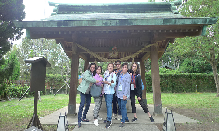 團員們歡欣喜悅在桃園神社手水舍前合照。手水舍：晉謁前除穢洗手、漱口及滌淨身心。貝